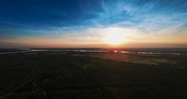 Dron günbatımında ormanın üzerinde göster.
