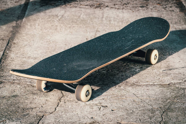 Skateboard on concrete floor in skatepark