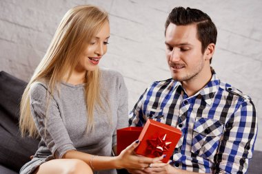 genç adam kanepede bir kız için bir hediye verir