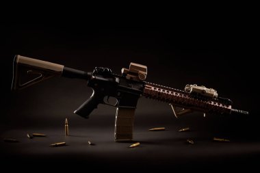 assault rifle and golden bullets on a black background clipart
