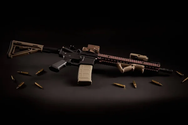 Rifle de assalto e balas douradas em um fundo preto — Fotografia de Stock