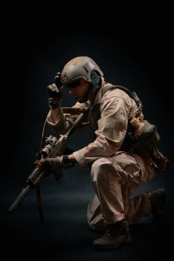 Özel Kuvvetler asker bir kask kafasına koyar.