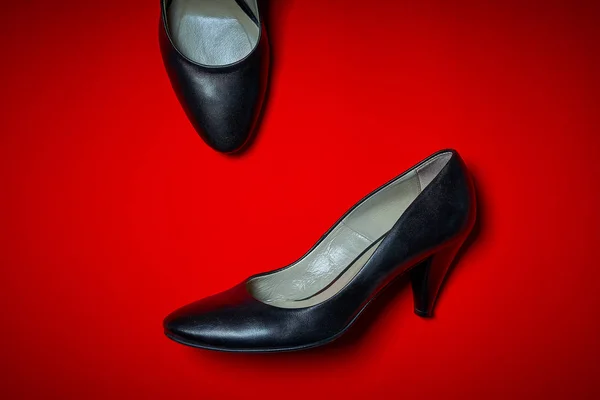 Widok z pary czarne buty na obcasie na czerwonym tle — Zdjęcie stockowe