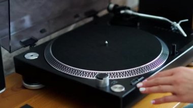 kadın pikap üzerinde döner ve müzik dinlemek için Lp koyar