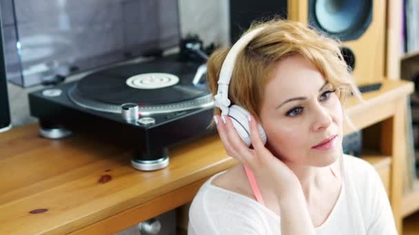 Beautiful Woman Sitting Next Turntable Headphones Her Head Listens Music — Stock Video