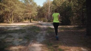 Spor kıyafeti kadında bir güzel yaz orman yoluyla çalışır
