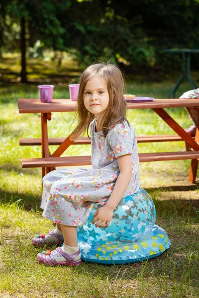 Girl sitting at a picnic table — Stock Photo, Image