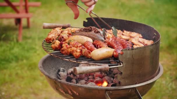 Close Woman Hand Holding Tongs Turning Grilling Sausages Barbecue Grill — Stock Video