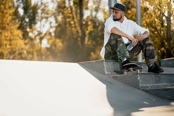 Hombre en skatepark con monopatín en cálido día de otoño —  Fotos de Stock