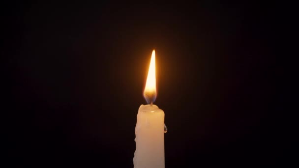 Nahaufnahme einer isolierten brennenden Kerze auf schwarzem Hintergrund — Stockvideo