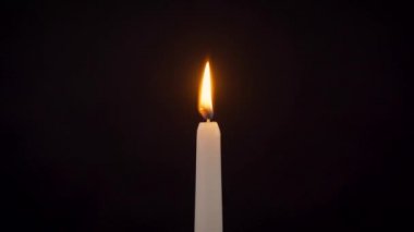 Siyah arka planda izole edilmiş yanan bir mumun yakın plan görüntüsü