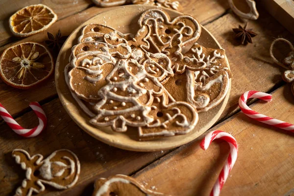 Christmas gingerbread on wooden plate on kitchen old table — Stock Photo, Image
