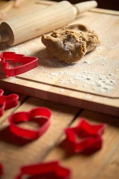 木製テーブルの上のクリスマスジンジャーブレッドとクッキーカッターのための生地 — ストック写真
