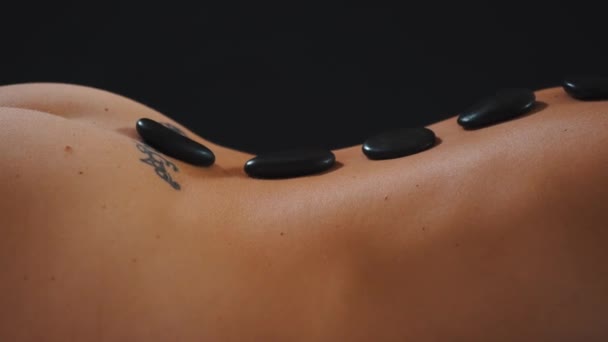 Масаж гарячим каменем на спині гола жінка — стокове відео