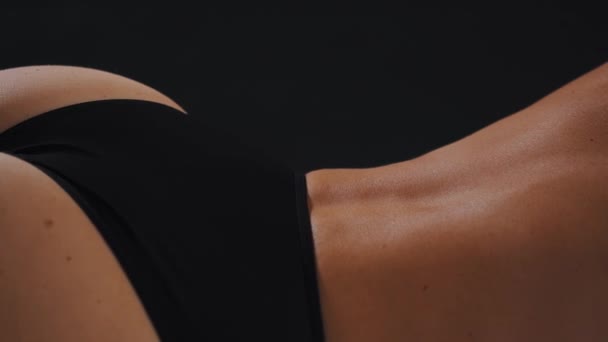 Mooie rug van een aantrekkelijke vrouw in zwart slipje — Stockvideo