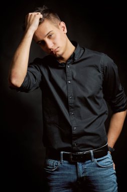 Siyah arka planda genç bir adamın moda portresi. 