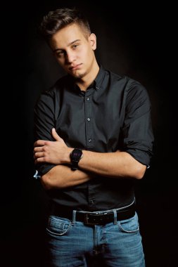 Siyah arka planda genç bir adamın moda portresi. 