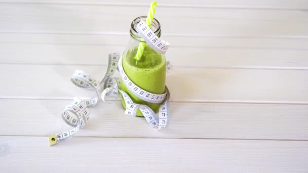 Cóctel verde y vegano saludable con cinta de centímetro en la mesa de madera blanca — Vídeo de stock