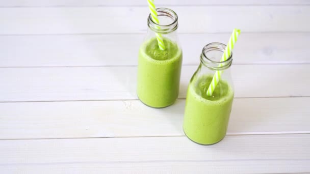 Gesunde grüne Früchte und vegane Cocktails auf weißem Holztisch — Stockvideo