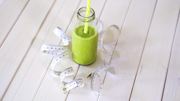zdravý zelený a veganový koktejl s centimetru na bílém dřevěném stole