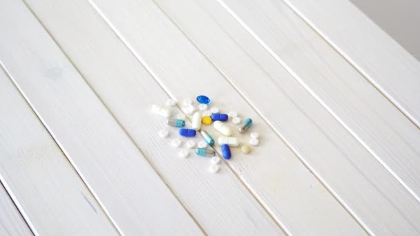 Набор различных таблеток на белом столе — стоковое видео