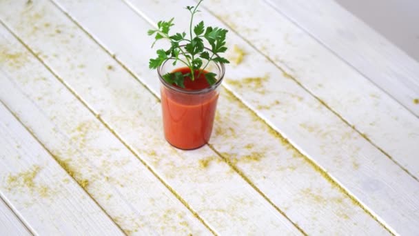 Saludable cóctel de tomate y vegano con ramita de perejil sobre mesa de madera blanca con arena — Vídeos de Stock