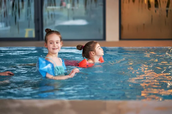 Roztomilé holčičky hrát a plavat v bazénu během prázdnin — Stock fotografie
