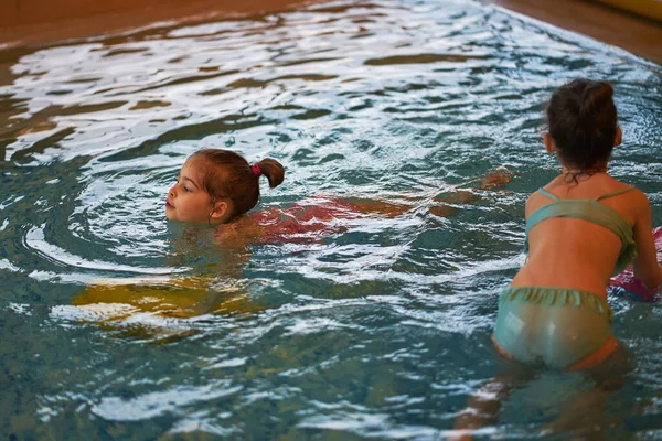 Entzückende kleine Mädchen spielen und schwimmen in den Ferien im Pool — Stockfoto