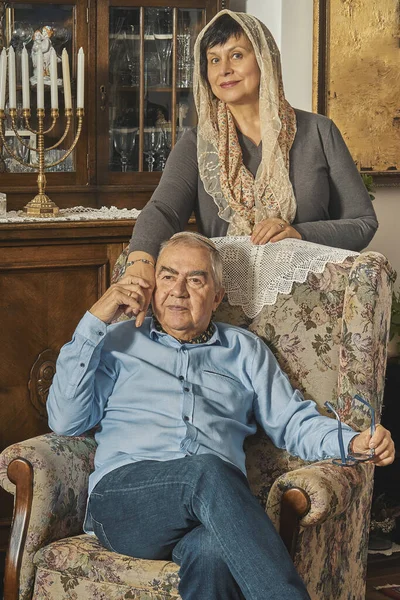 Pareja mayor judía posa en sillón en casa tradicional —  Fotos de Stock