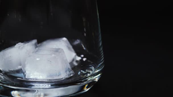 Whisky d'oro versato in un bicchiere vuoto — Video Stock