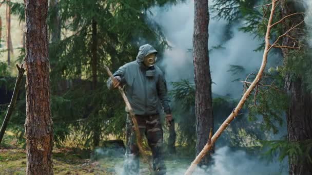 Ένας άντρας με μάσκα αερίων περπατά στο δάσος με αέριο. — Αρχείο Βίντεο