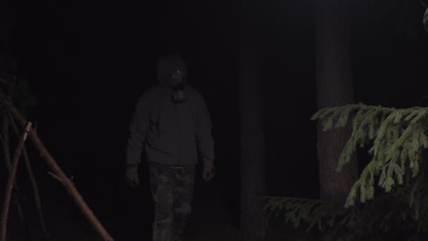 Muž v plynové masce uniká z koronaviru v lesích v noci — Stock video