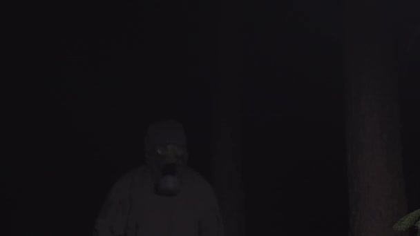 Man in a gas mask escapes from coronavirus in the woods at night — Stock Video