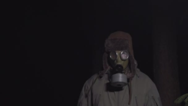 Man in a gas mask escapes from coronavirus in the woods at night — Stock Video