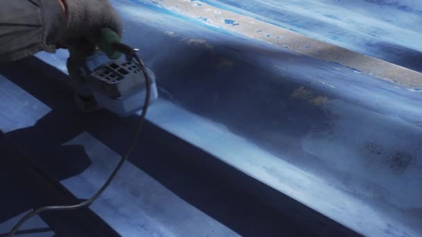 Ręka człowieka ze szlifierką, który naprawia niebieską łódź — Wideo stockowe