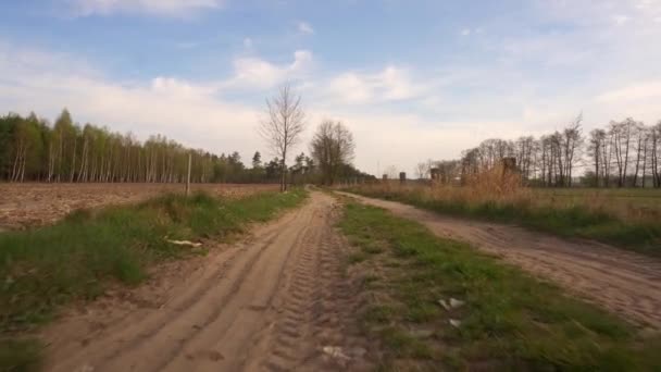 Caminar por el camino arenoso entre los campos en el pueblo — Vídeo de stock