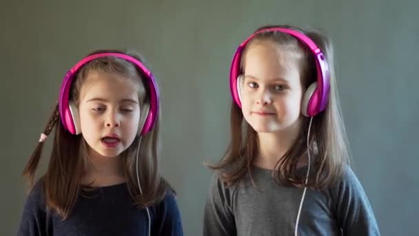 Dos chicas adorables con auriculares escuchar música y bailar — Vídeo de stock