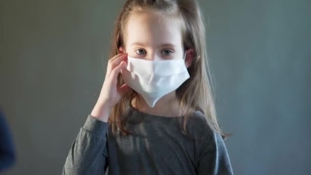 Adorable little girl wearing a white mask on her face — Stock Video