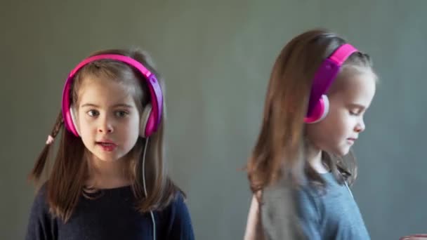 Dos chicas adorables con auriculares escuchar música y bailar — Vídeo de stock