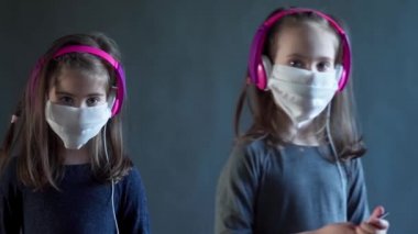 Kulaklıklı iki sevimli kız müzik dinliyor.