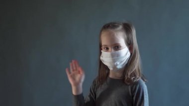 Yüzüne beyaz bir maske takan sevimli küçük bir kız.