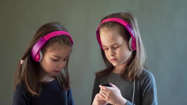 Dos chicas adorables con auriculares escuchar música y bailar — Vídeo de stock