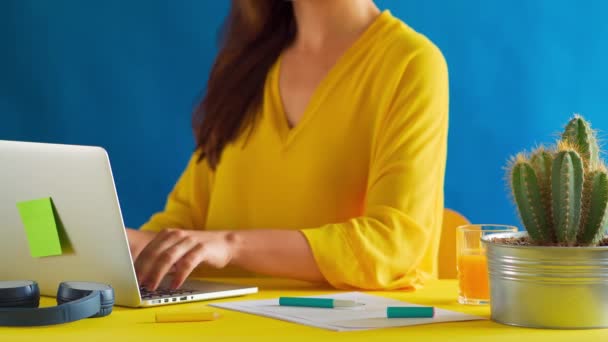 Woman in a yellow blouse works remotely at home during a pandemic — Stock Video