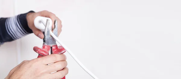 Man cutting wire with pliers.