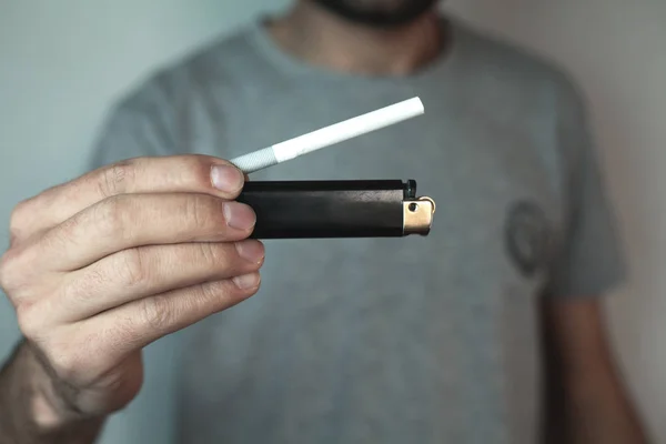 Homem mostrando isqueiro e cigarro . — Fotografia de Stock