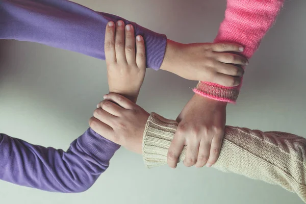 Las manos de los niños se unen sobre la mesa . — Foto de Stock