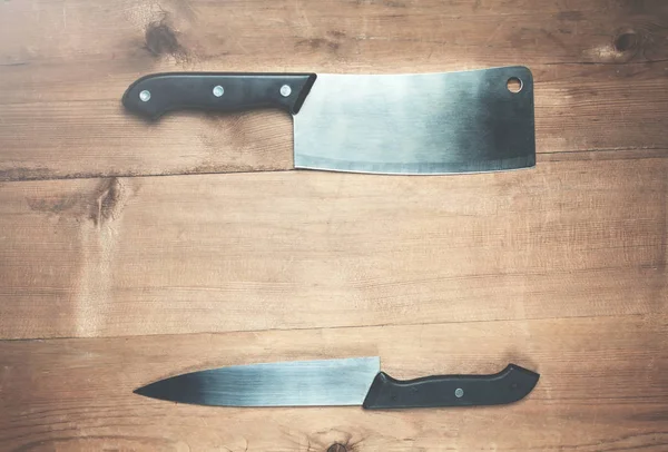 Kitchen knifes on a wood background.