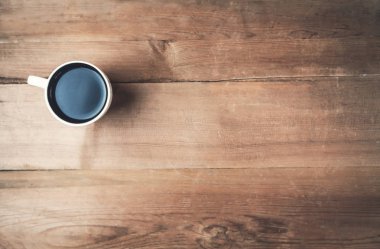 Ahşap arka plan üzerinde beyaz kahve fincanı.