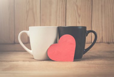 Ahşap arka plan üzerinde kırmızı kalp ile kahve fincanı.