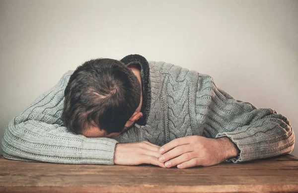 Sleeping man on the wooden desk.